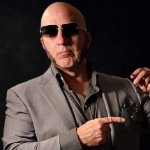 Faggot brainwashing Master, The Shadow Priest, in a grey suit, pointing at a pocketwatch